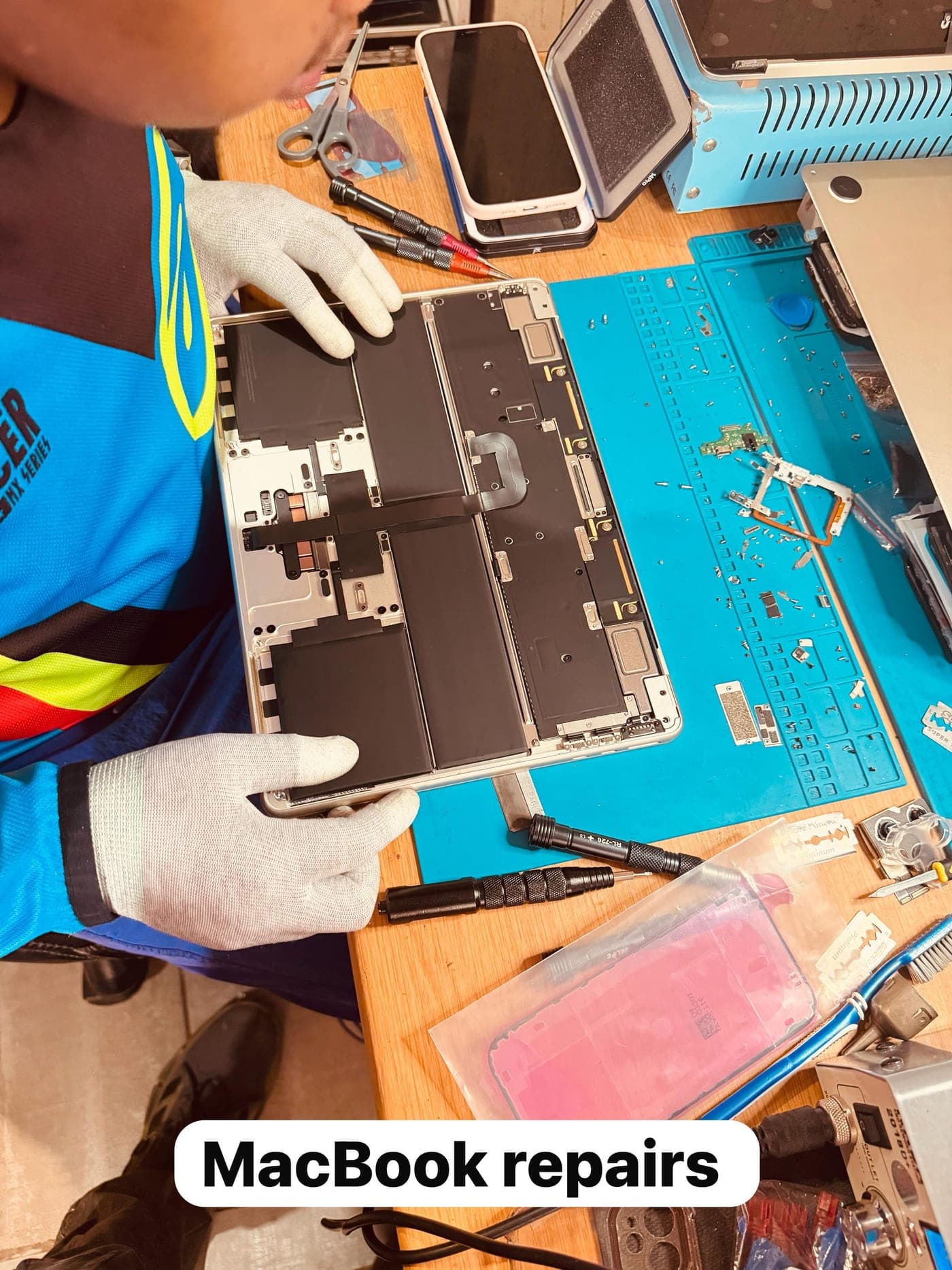 A MacBook opened up on the workbench during a battery replacement